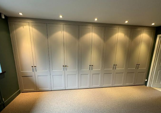 Fitted bedroom wardrobes with modern panelled doors and spotlights