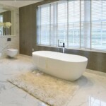 marble bathroom with free standing white toilet