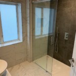 marble bathroom with black tilled shower