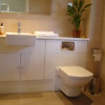 white bathroom with green plant next to sink