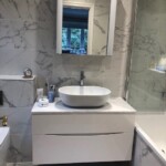 white and marble bathroom with glass cabinet