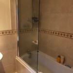 brown bathroom with glass shower door
