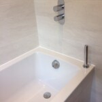 close up of bath with silver taps and plugs