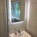 white sink with a rectangular mirror with rounded edges