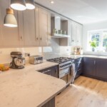 black and white kitchen with marble worktop with cooker