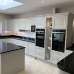 black sparkly worktop with white cupboards in kitchen