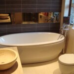 rounded bath with mirror hanging above