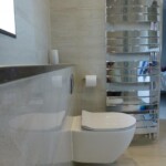 white toilet with silver waved towel rail