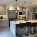 grey kitchen with dark grey seats next to island