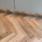 Wooden herringbone flooring in a modern interior space